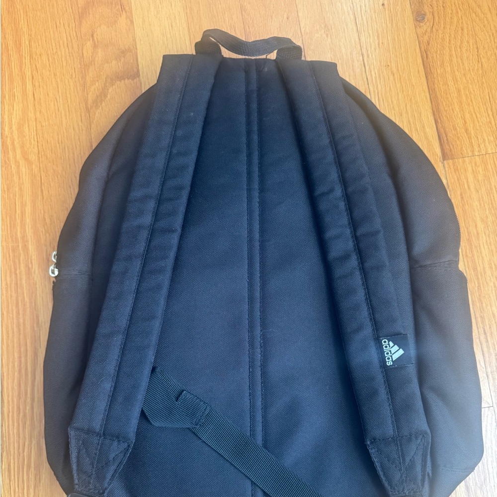 Adidas black lightweight backpack. Gold logo on top and gold front zipper.